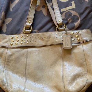 Tan coach purse with studs.